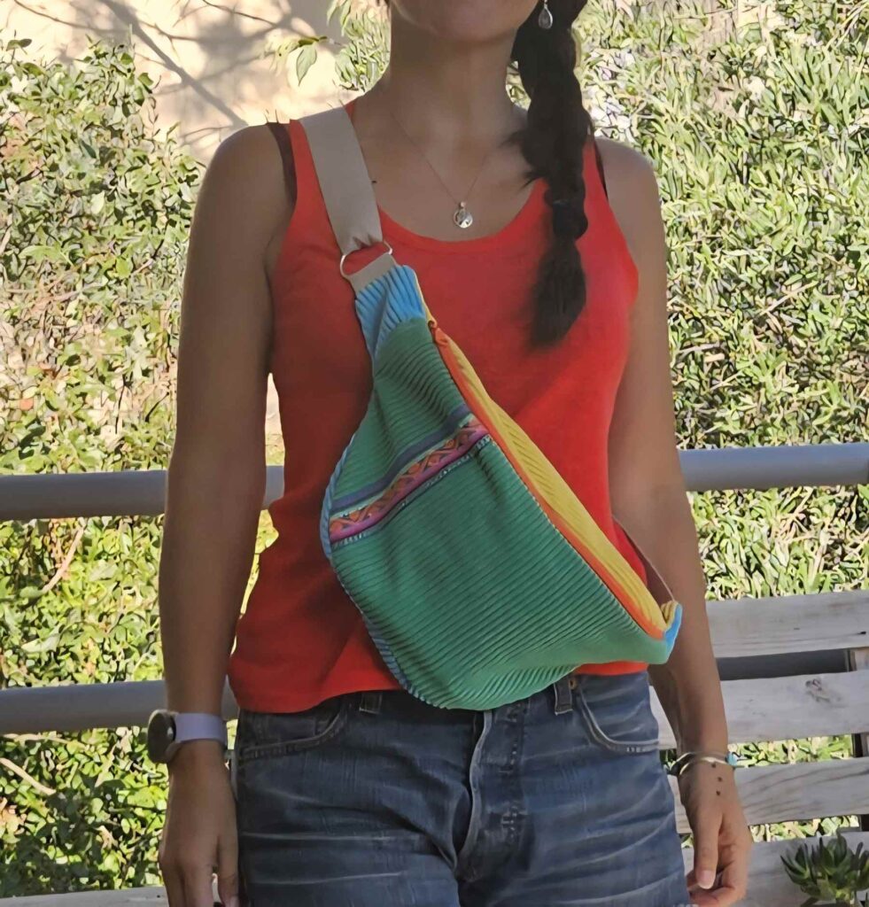 Femme portant un sac banane Andina vert en velours côtelé avec ruban péruvien coloré